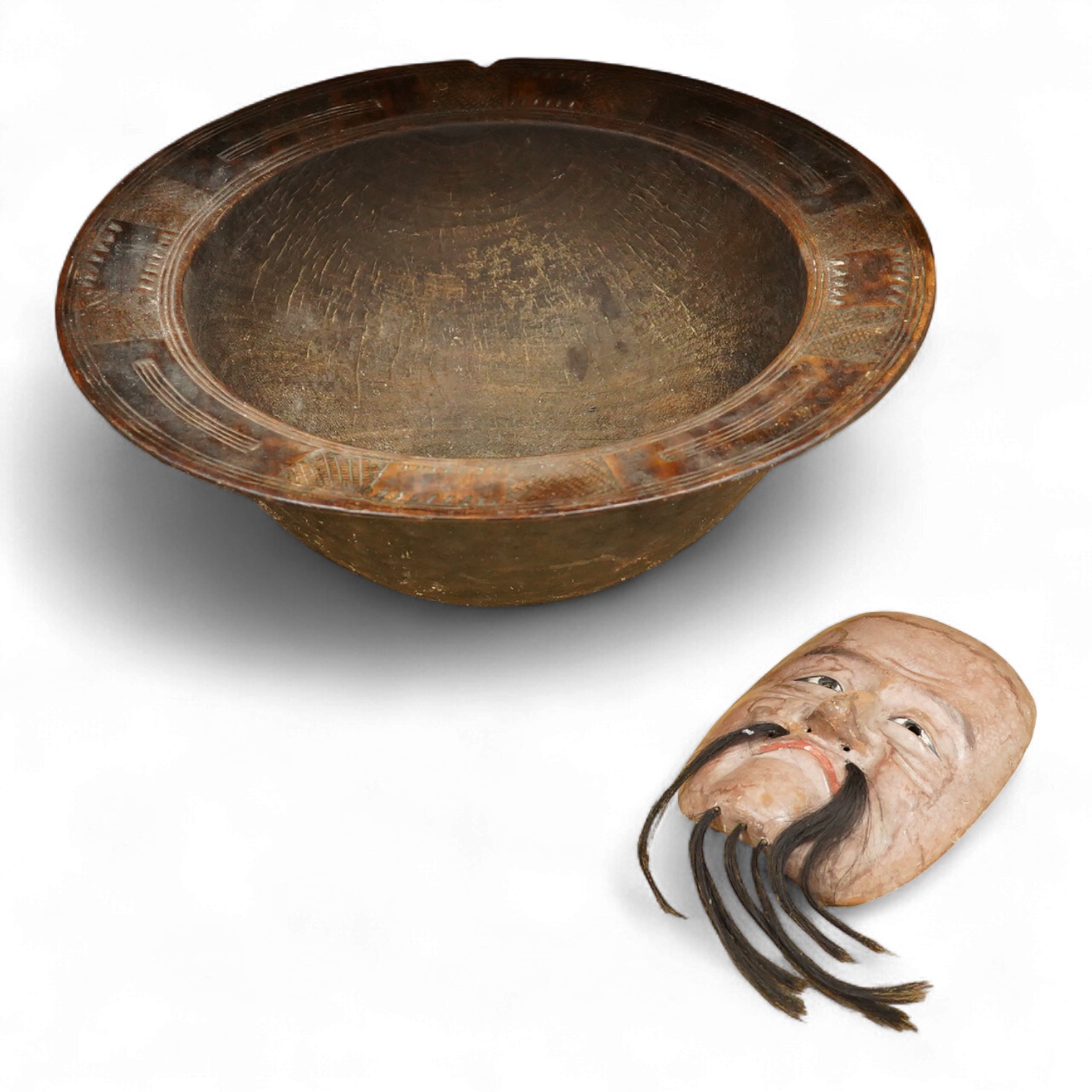 A wooden bowl with a decorative carved rim - 44cm wide across rim and an oriental carved and painted wooden face mask